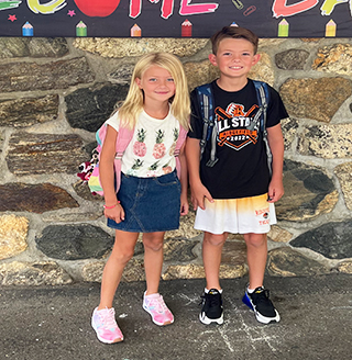 Two happy elementary students in the school hallway