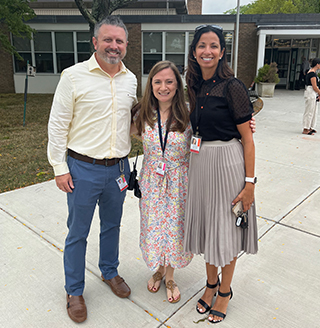 Superintendent with two adults outside school