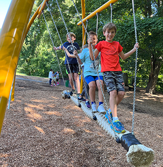 Happy students standing on a swing