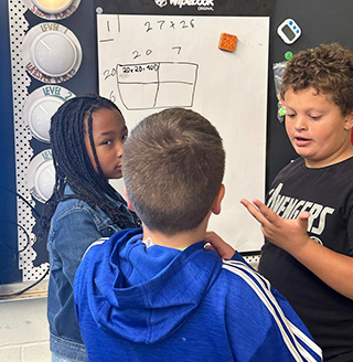 Three students working together on a project in the classroom