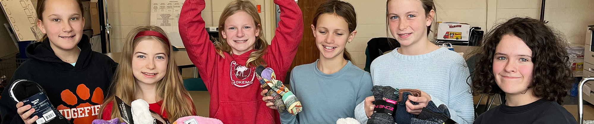 Group of happy middle school girls collecting socks