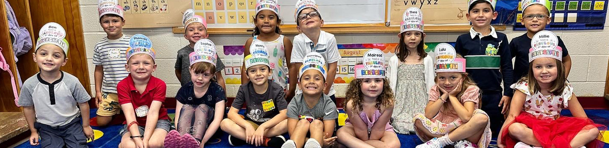 Class of younger students wearing paper hats