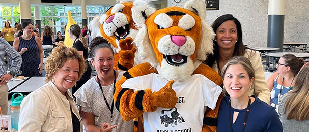 Teachers posing with tiger mascots