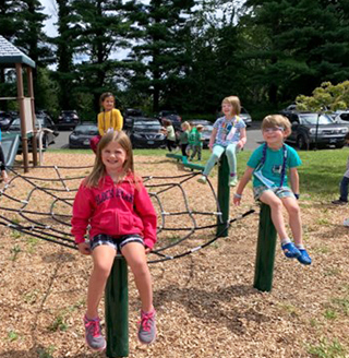 Elementary students playing on the playground equipment