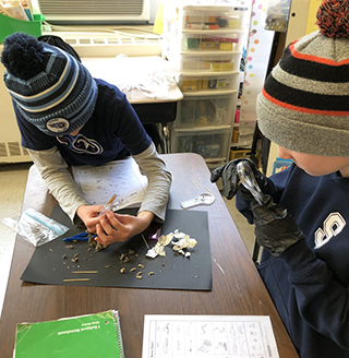 Two students studying owl pellets